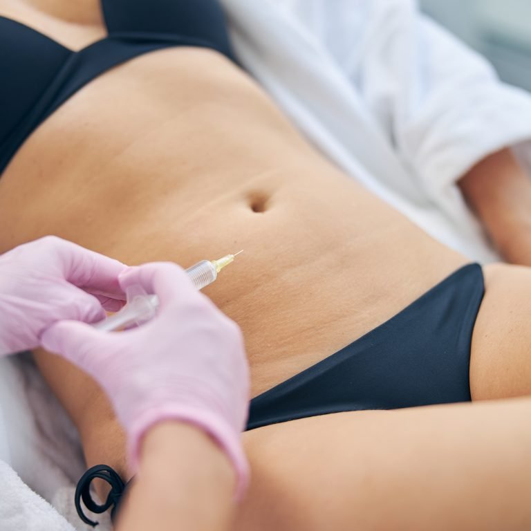 Cropped photo of a doctor administering a subcutaneous injection to an adult Caucasian female patient