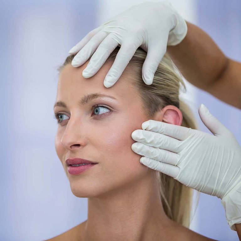 Doctor examining female patients face from cosmetic treatment
