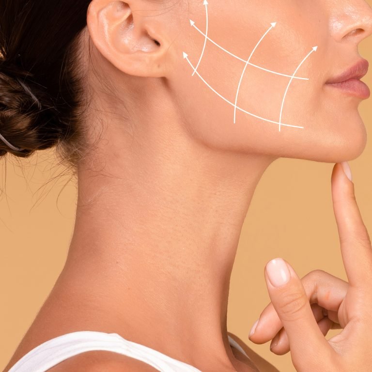 Profile of young woman with clean fresh skin, antiaging concept. Lady touching chin, lifting arrows showing facial anti-aging treatment on skin, panorama, free space